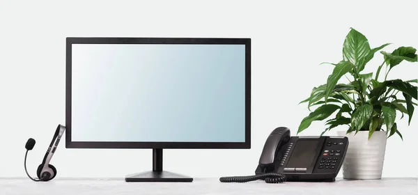 Комп'ютерний монітор VOIP гарнітура телефон на столі в сучасному офісі. телекомунікацій — стокове фото