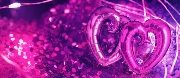Two Foil Heart shaped balloons on pink — Zdjęcie stockowe