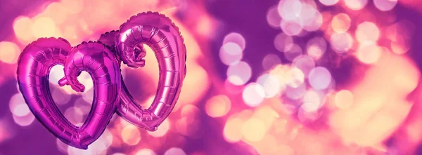 Two Foil Heart shaped balloons on pink — Stockfoto
