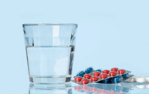 青いテーブルの上の白い錠剤または錠剤の背景。医薬品 — ストック写真