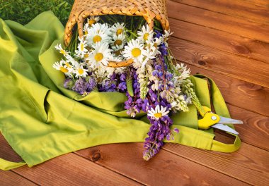 Tahta bir verandada sepetin içinde güzel yaz çiçekleri