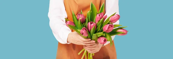 Woman or florist holding a bunch of red tulips on blue — Stock Photo, Image