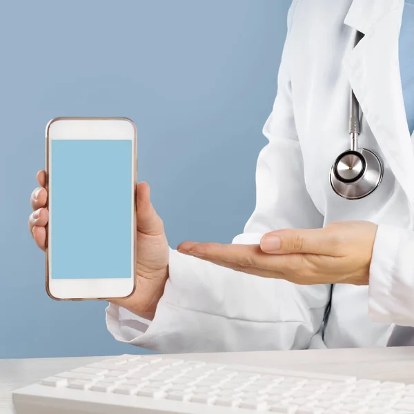 Doctor holding a mockup smartphone with an medical app — Stock Photo, Image