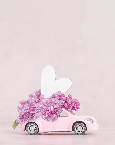 Lilac flowers on top of retro pink car with heart — Φωτογραφία Αρχείου