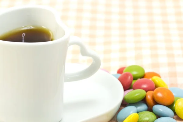 Šálek kávy a barevné čokoládě — Stock fotografie