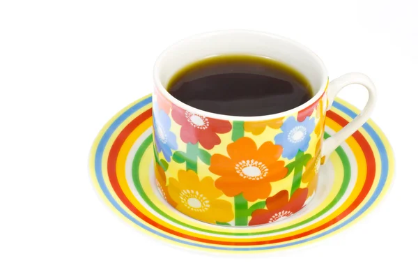 Καφέ που χύνεται σε ένα φλυτζάνι του καφέ με ένα λουλούδι μοτίβο — Φωτογραφία Αρχείου