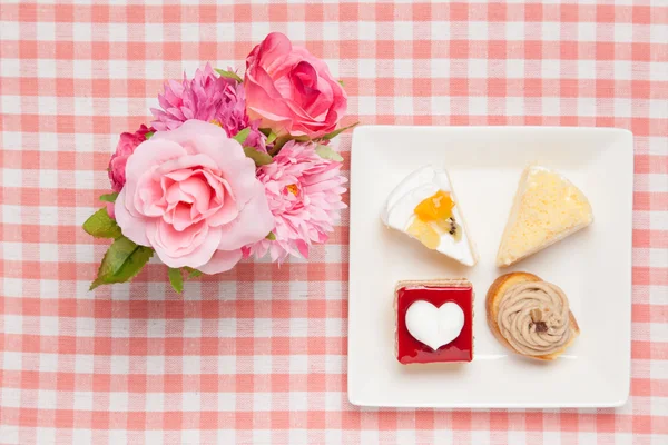 Mini-Shortcakes und künstliche Rosen — Stockfoto