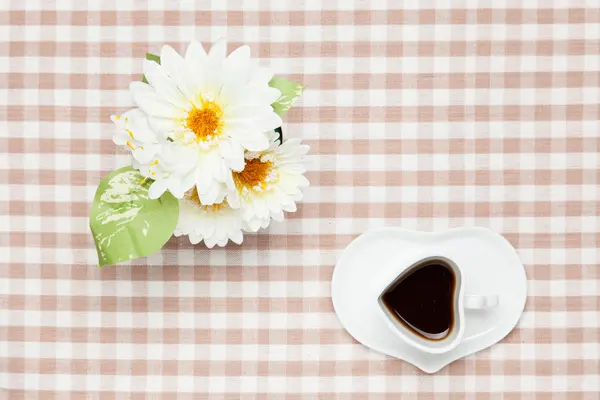 Kaffee und weiße Kunstblumen — Stockfoto
