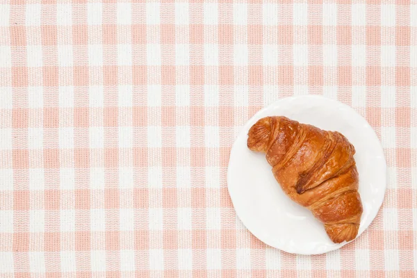 Croissant auf der Tischdecke — Stockfoto