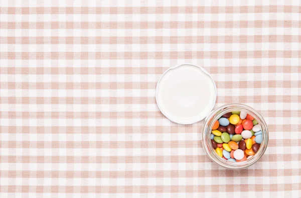 Kleurrijke chocolade werd geplaatst in een glazen fles — Stockfoto