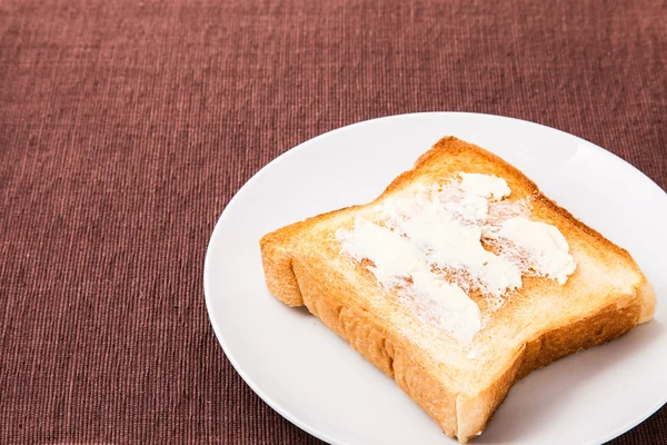 Kızarmış ekmek ve bir tabak üzerinde yerleştirilmiş tereyağı — Stok fotoğraf