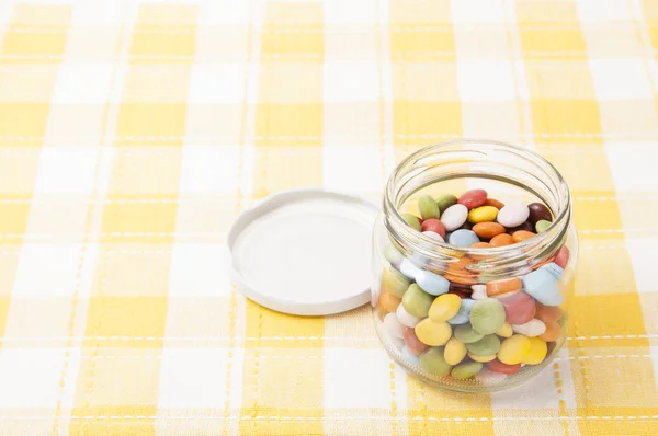 Kleurrijke chocolade werd geplaatst in een glazen fles — Stockfoto