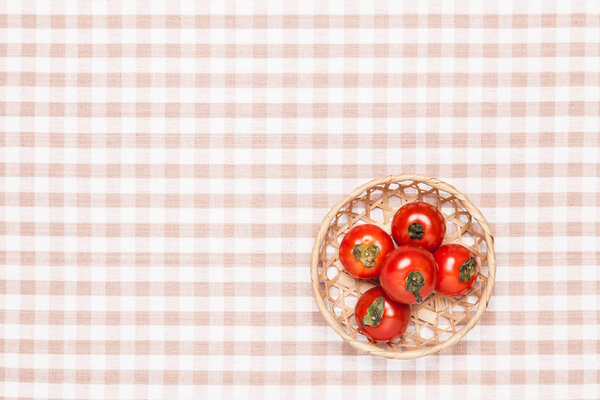 tomatoes on the table and put it in a basket