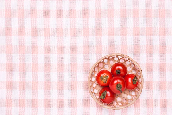 Tomatoes on the table and put it in a basket — Stock Photo, Image