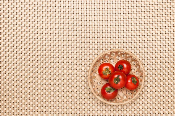 Tomatoes on the table and put it in a basket — Stock Photo, Image