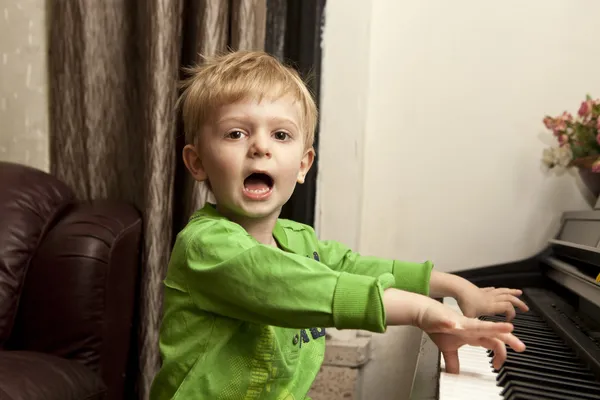 Jongen spelen op piano. Rechtenvrije Stockafbeeldingen