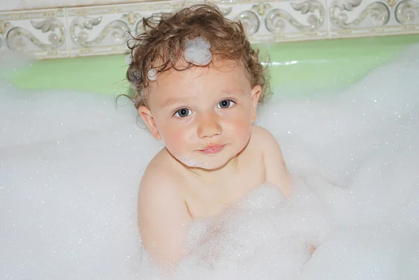 Boy sitting in the foam — Stock Photo, Image