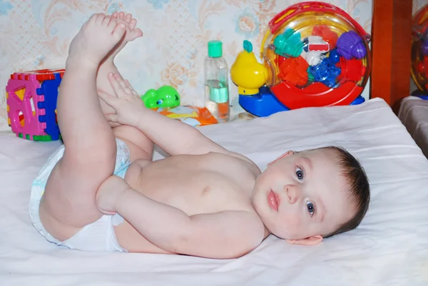 Baby is lifted leg up — Stock Photo, Image