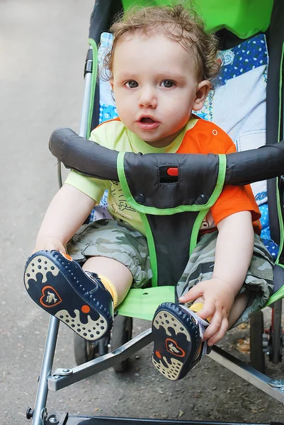 Мальчик, сидящий в коляске — стоковое фото