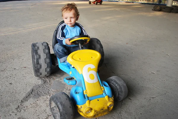 Um menino montando um carro — Fotografia de Stock