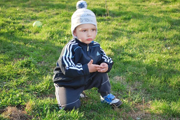 Sad boy sitting on the grass — Stock Photo, Image