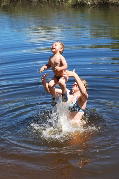 El niño y la niña se sumerge bañado, salta al río . — Foto de Stock