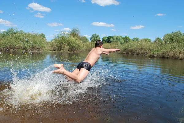 Chłopiec jest kąpała nurkowań, skacze do rzeki — Zdjęcie stockowe