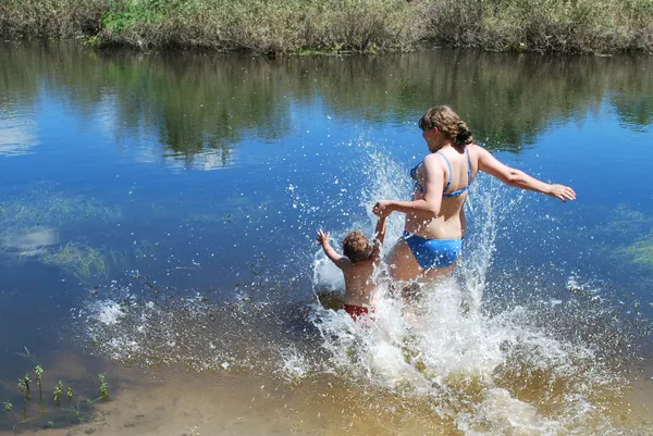 Chłopiec i dziewczynka jest kąpała nurkowań, skacze do rzeki. — Zdjęcie stockowe