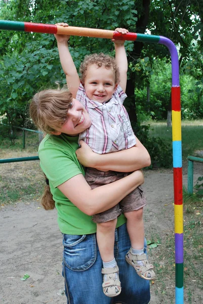 The playground, the boy was hanging on the bar, and my mother hu — Stock Photo, Image