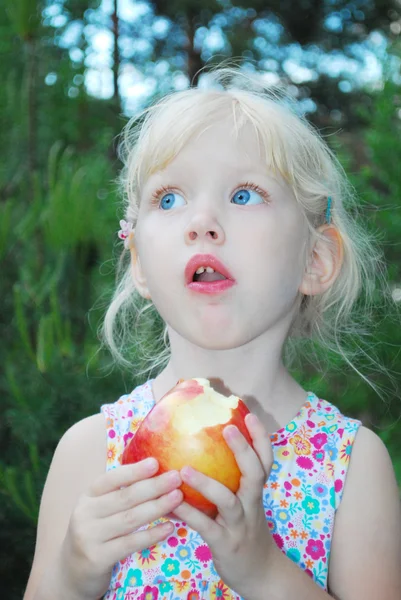 Menina está comendo maçãs . — Fotografia de Stock