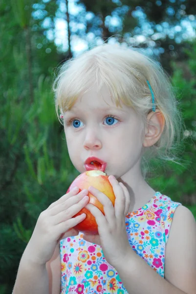 Kleines Mädchen isst Äpfel. — Stockfoto