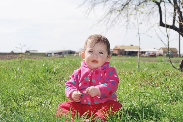 Bambina è seduta sull'erba — Foto Stock