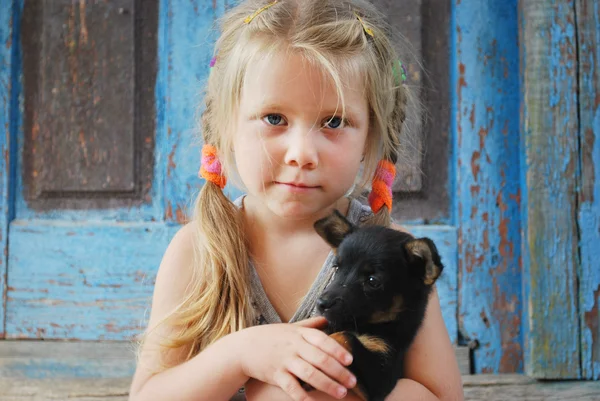 A small village girl holding a dog — Stock Photo, Image