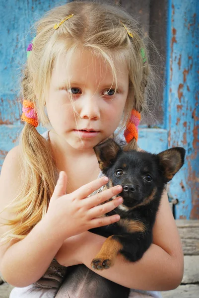 Un pequeño pueblo triste chica sosteniendo un perro — Foto de Stock