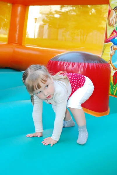 No parque de diversões, saltando em uma menina inflável da corrediça . — Fotografia de Stock