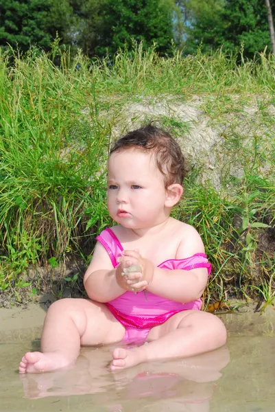 A little girl swims in the river. — Stock Photo, Image