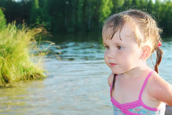 A little girl swims in the river. — Stock Photo, Image