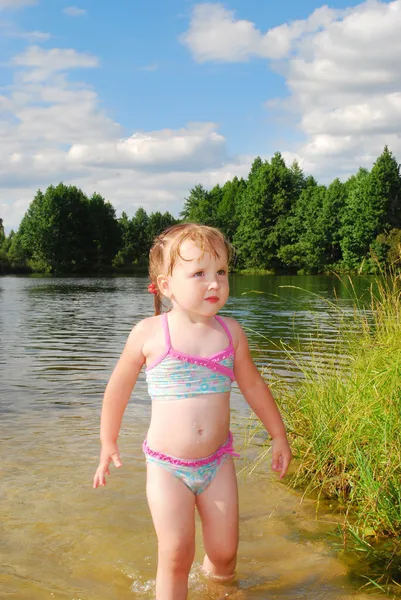 A little girl swims in the river. — Stock Photo, Image