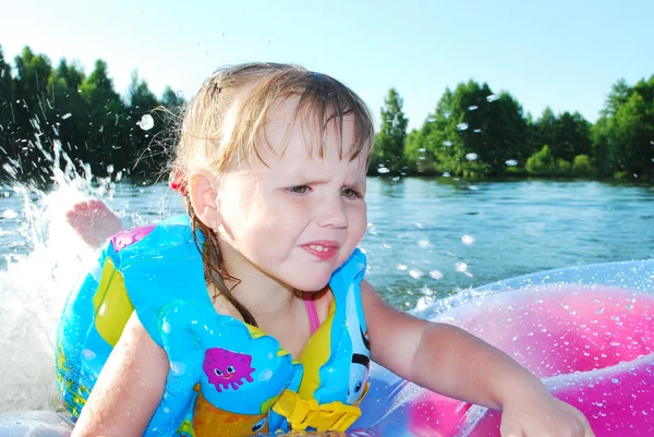 A little girl swims in the river. — Stock Photo, Image