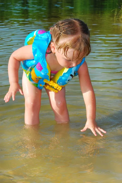 Ein kleines Mädchen schwimmt im Fluss. — Stockfoto