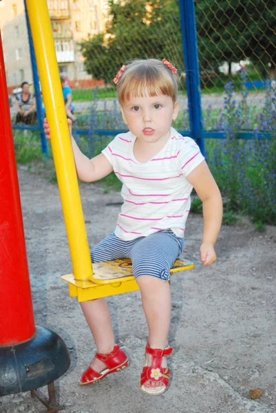 Lustiges kleines Mädchen spielt auf dem Spielplatz. — Stockfoto