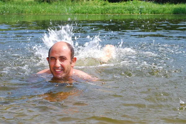 Člověk je koupeme ponory, do řeky. vedle něj sprej. rostoucí o — Stock fotografie