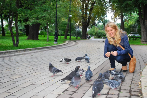 El parque, la niña alimentando palomas — Foto de Stock