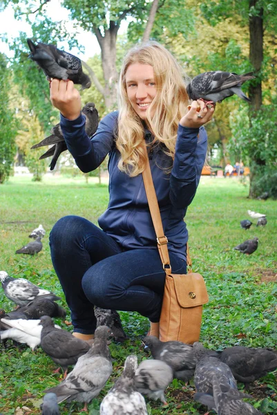 Der Park, das Mädchen, das Tauben füttert — Stockfoto