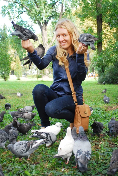 Le parc, la fille qui nourrit les pigeons — Photo