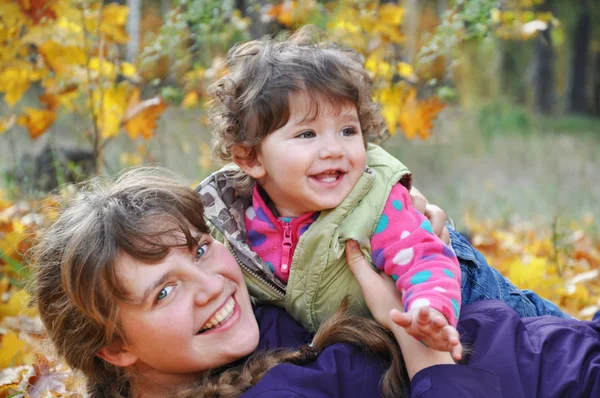 Mamma leker med sin dotter, dabbles i skogen höst — Stockfoto