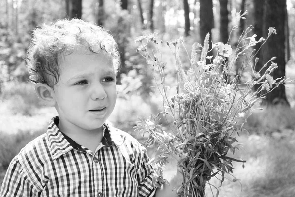 Bambino sconvolto con un mazzo di fiori — Foto Stock