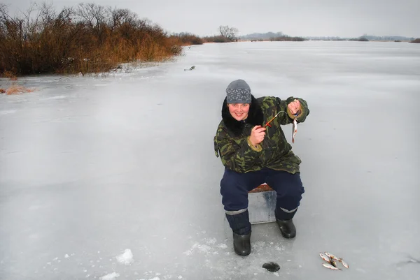 Vinter fiskare på floden att fånga fisk — Stockfoto