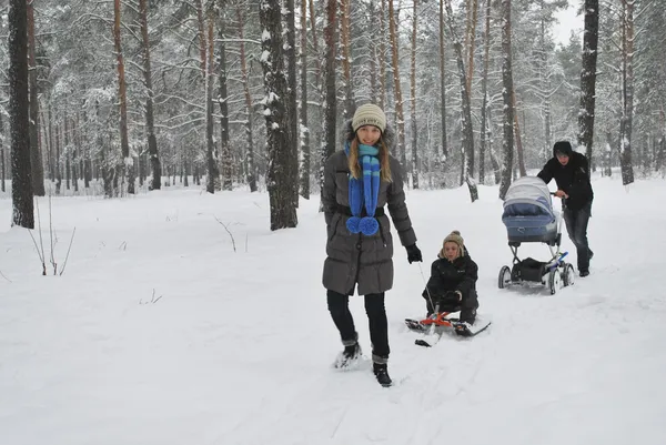Family on a walk in a winter snow-covered forest. — Stock Photo, Image