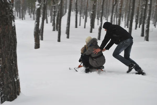 Family on a walk in a winter snow-covered forest. — Stock Photo, Image